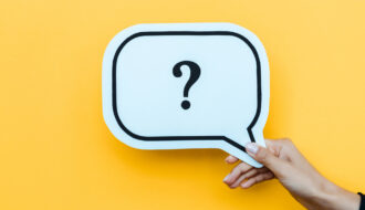 Ręka trzymająca znak ze znakiem zapytania